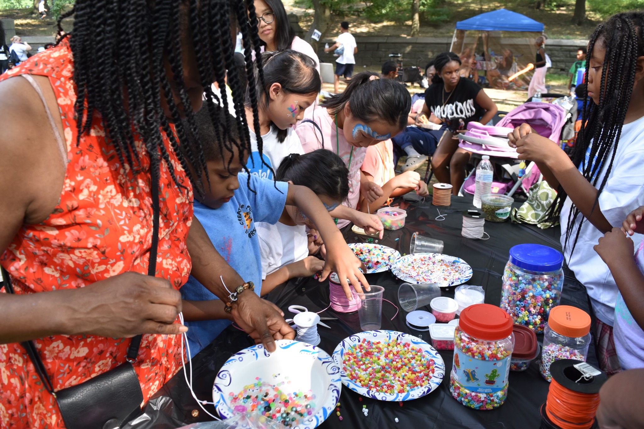 Children creating bead crafts together at Children’s Day