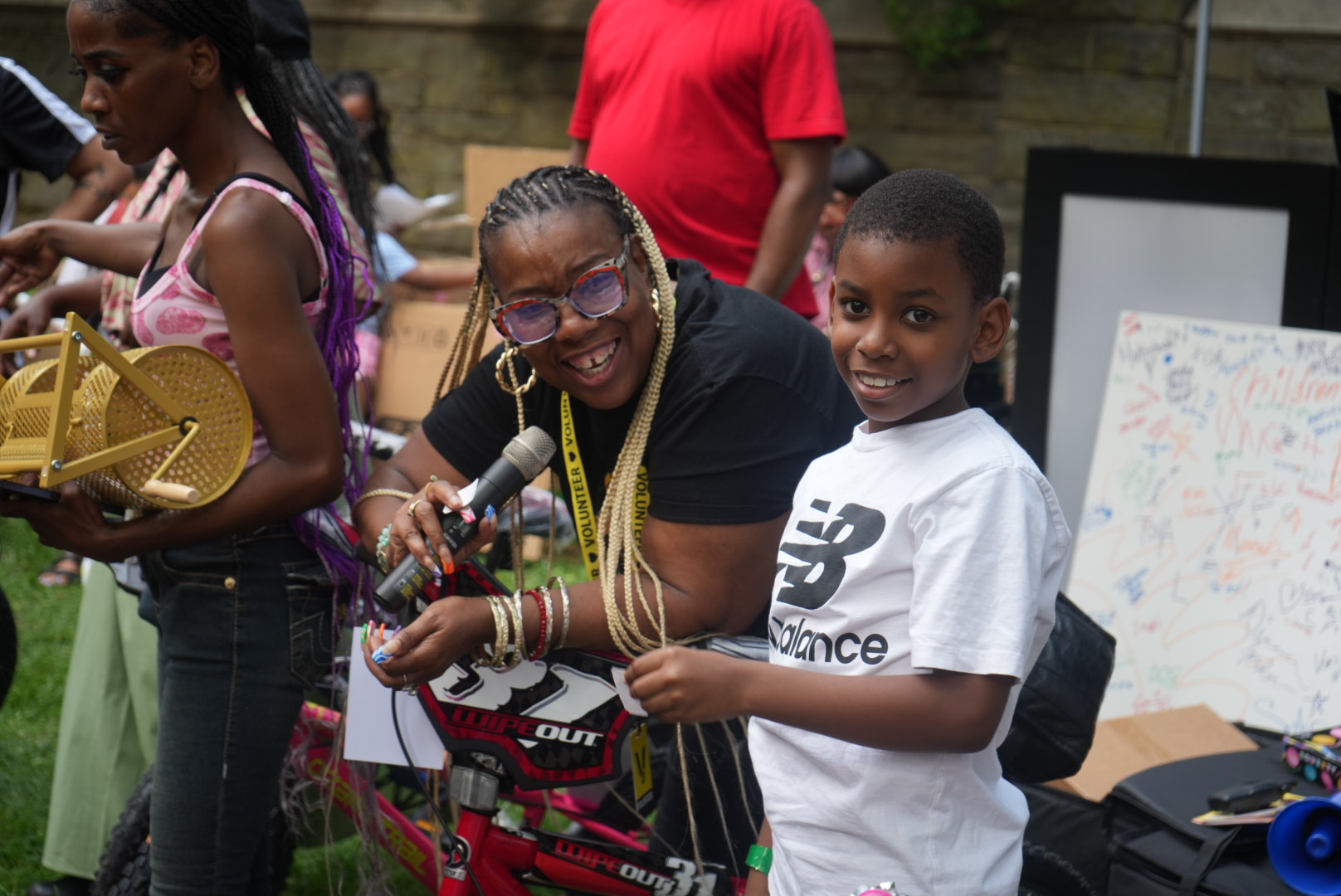 A woman holding a microphone with a child beside her at a UFOS community event