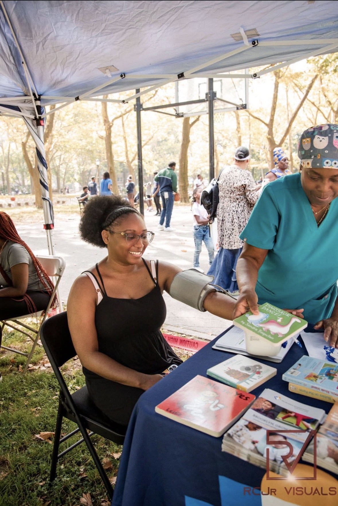 A healthcare professional providing a blood pressure screening for a community member at a UFOS event