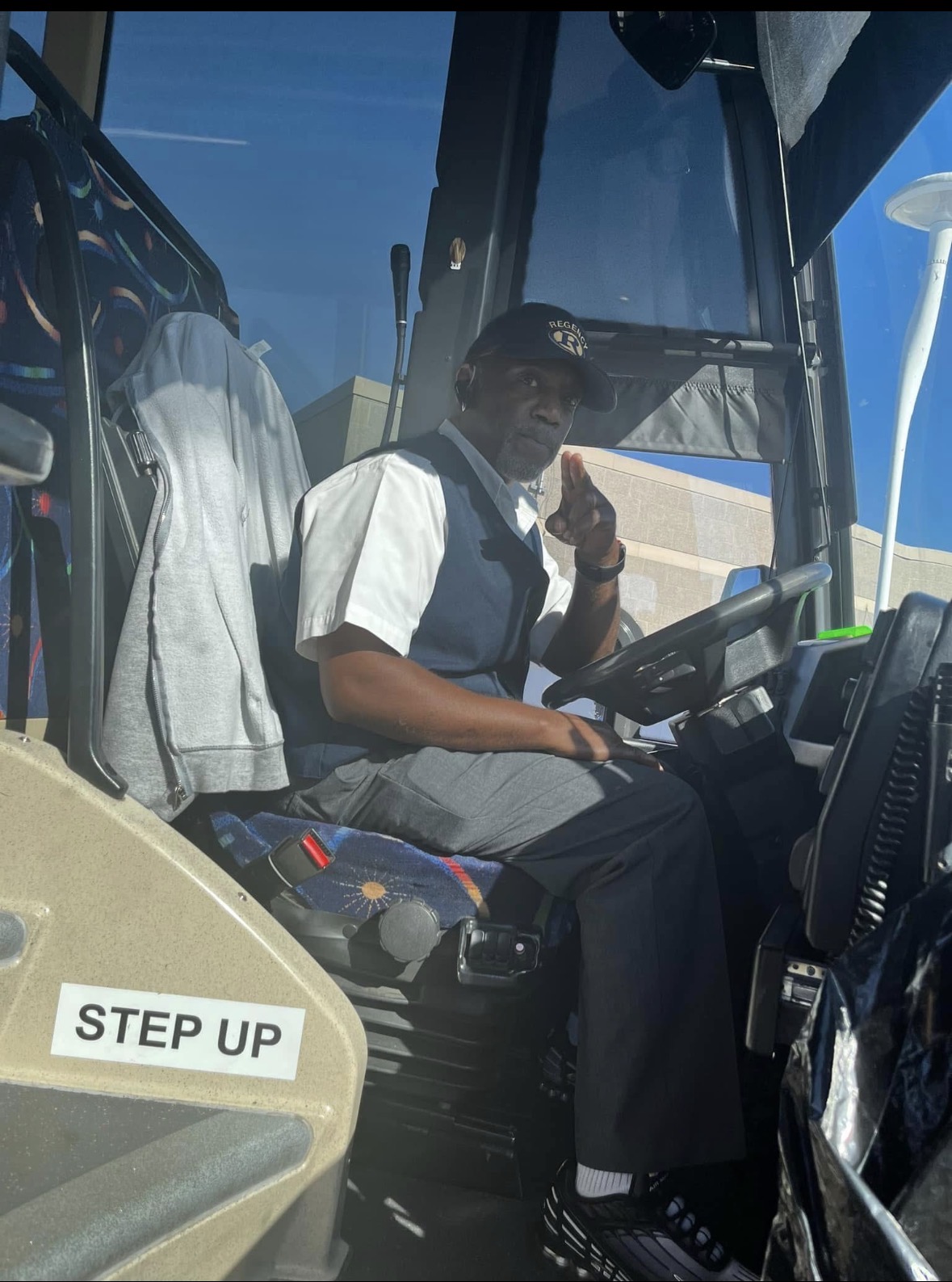 Shatiek seated at the wheel of a bus
