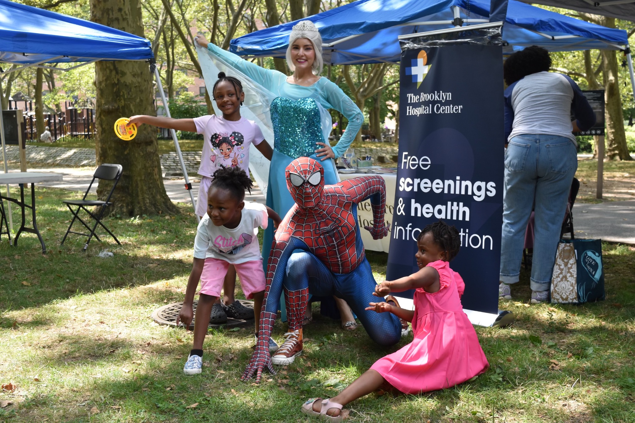 Children posing with Spider-Man and Elsa at Children’s Day