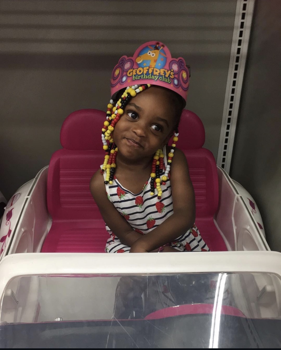 Isabella smiling in a birthday crown as a little girl