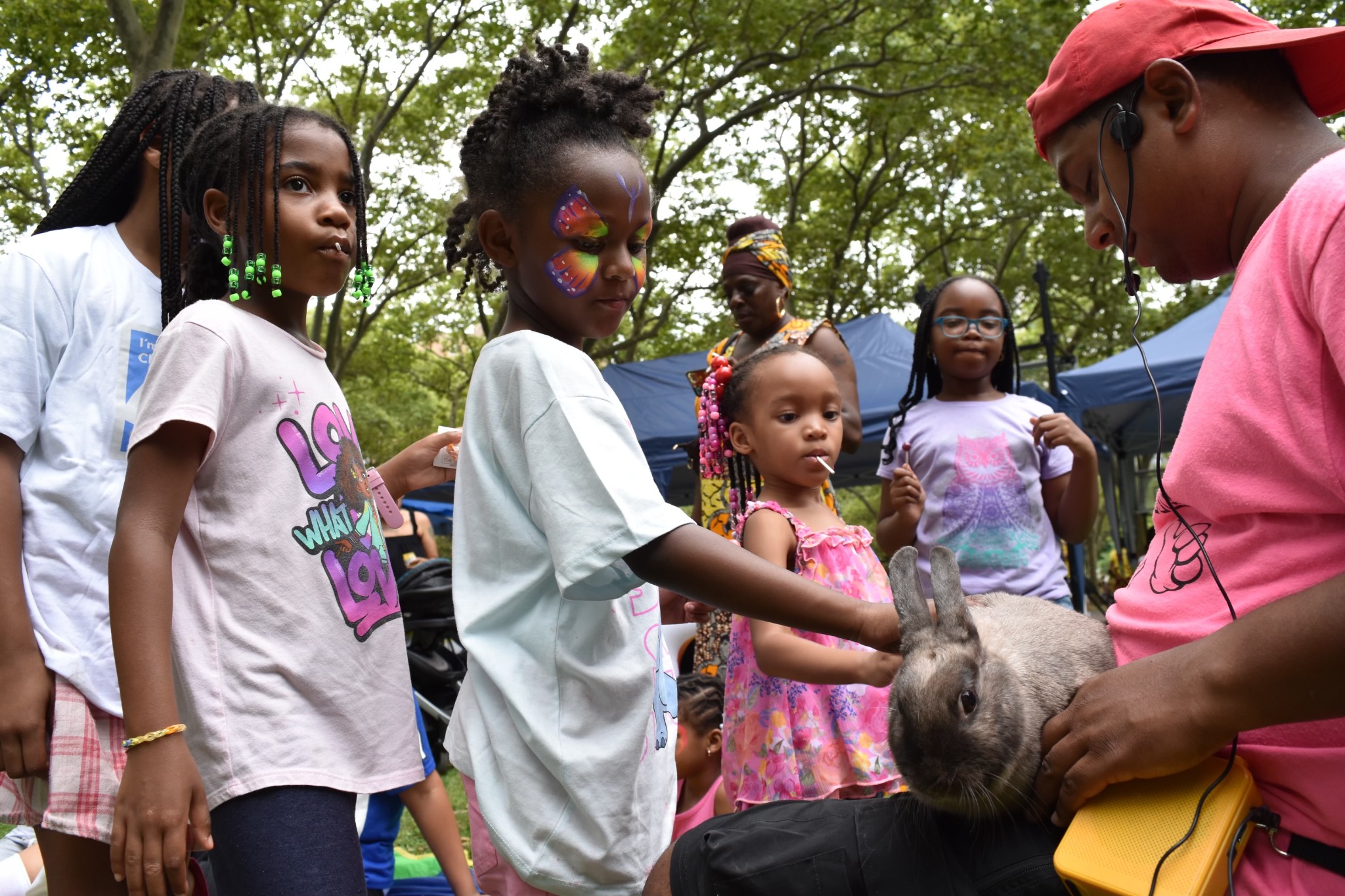 Children interacting with a rabbit at the Children’s Day petting zoo